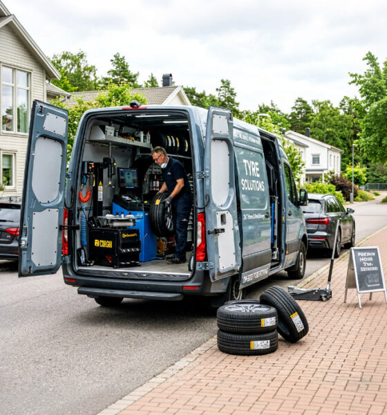 Técnico especializado realizando un cambio neumaticos a domicilio con equipamiento profesional junto a un coche estacionado en una vivienda. Imagen ideal para ilustrar comodidad, seguridad y montaje profesional de neumáticos sin acudir al taller. muchoneumatico.com