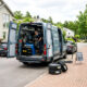 Técnico especializado realizando un cambio neumaticos a domicilio con equipamiento profesional junto a un coche estacionado en una vivienda. Imagen ideal para ilustrar comodidad, seguridad y montaje profesional de neumáticos sin acudir al taller. muchoneumatico.com
