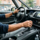 Primer plano realista del selector automático de una caja CVT con la mano del conductor cambiando a posición D para conducción urbana diaria.