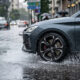 Ilustración realista de un coche reduciendo velocidad en asfalto mojado durante lluvia intensa, mostrando cómo los frenos mojados afectan la distancia de frenado y la seguridad.