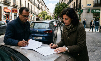 Dos personas firmando un contrato de compraventa de vehículo usado.