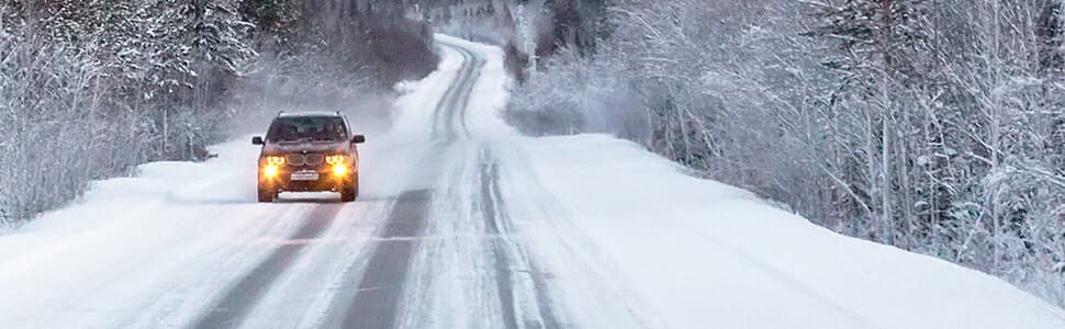 Carretera nevada y coche en marca